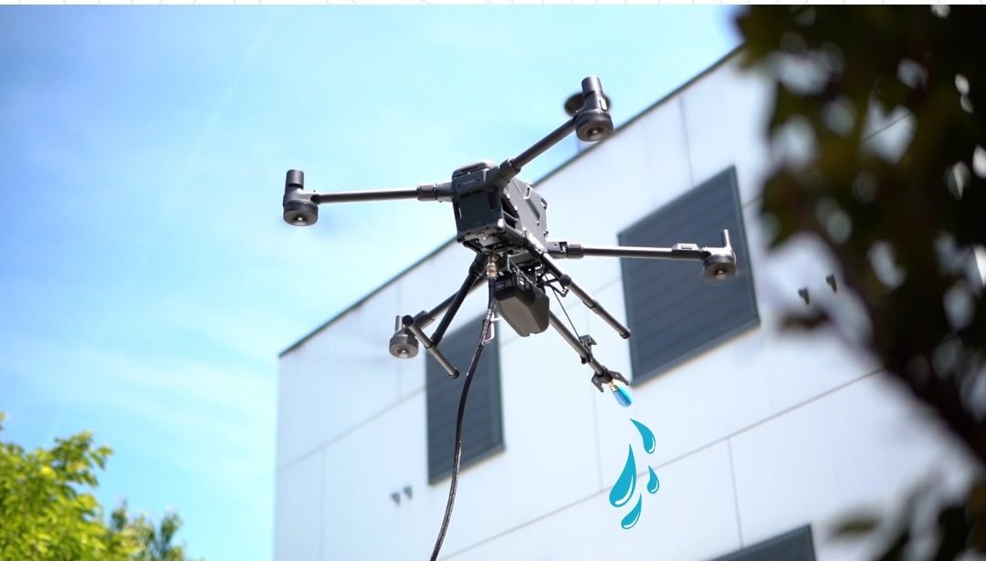 Drone de nettoyage en vol stationnaire devant une façade blanche